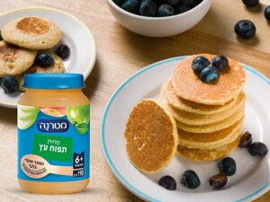 מתכונים בשילוב מחיות מטרנה. ערימת פנקייקים על צלחת ולצידה מחית מטרנה