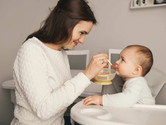 אמא מאכילה את תינוקה בדייסה