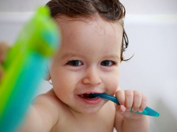תינוק באמבטיה מצחצח את שיניו