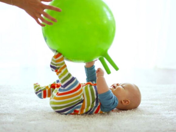 תינוק משחק עם כדור גדול