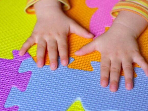 ידי תינוק על משטח סול צבעוני