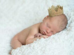 תינוק קטן ישן עירום ולראשו כתר