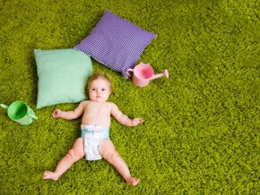 תינוק שוכב על הדשא כשלגופו חיתול