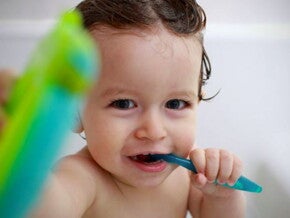 תינוק באמבטיה מצחצח את שיניו