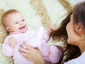 תינוק צוחק לבוש בבגד ארוך עם אימו