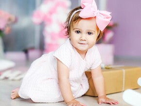 תינוקת עם סרט ורוד לראשה