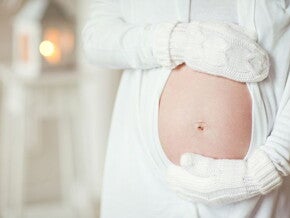 הריונית עם כפפות מחבקת את ביטנה