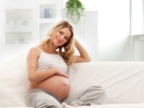 הריונית שמחה על הספה