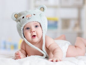 תינוק שוכב על ביטנו עם כובע