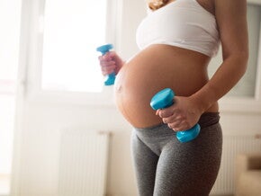 הריונית מחזיקה משקולות