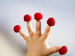 תותי עץ על אצבעותיו של פעוט