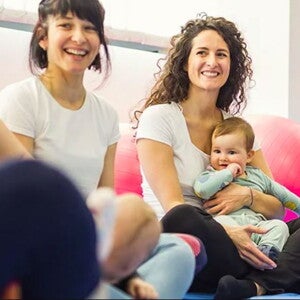 נשים יושבות וצוחקות עם תינוקותיהן על בירכיהן