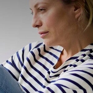 אישה אחרי לידה מביטה לפנים בעצבות