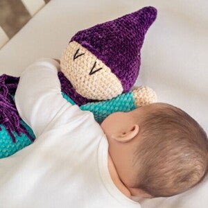 תינוק קטן מחבק בובה רכה במיטתו בעודו ישן