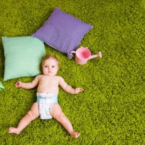 תינוק שוכב על הדשא כשלגופו חיתול