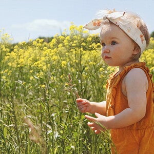 פעוטה על רקע פריחה אביבית