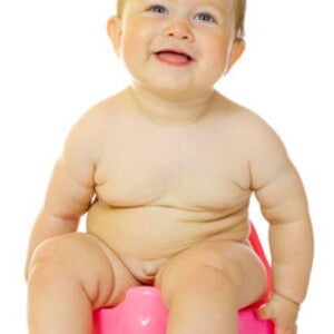 תינוק יושב על סיר ומחייך