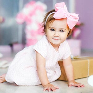 תינוקת עם סרט ורוד לראשה