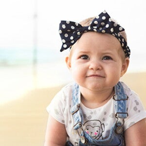 פעוטה זוחלת עם סרט על ראשה