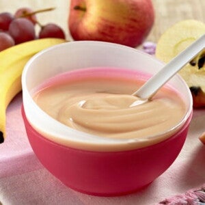 קערה עם מחית פירות על שולחן מלא בפירות