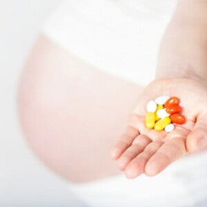 הריונית מחזיקה בידה תוספי תזונה