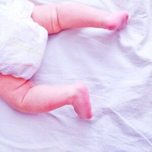 תינוק שוכב על בטנו ולגופו חיתול