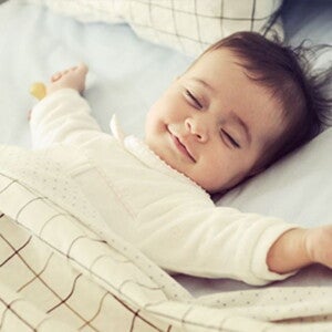 פעוט ישן ומחייך במיטתו