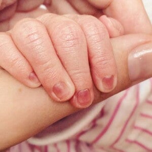 יד של תינוק שרק נולדת אוחזת היד אמו