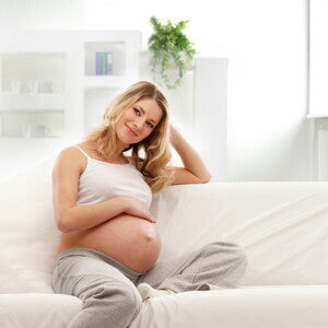 הריונית שמחה על הספה