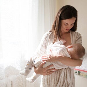 אם מחזיקה את תינוקה על הידיים