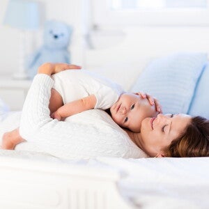 אמ ותינוקה מחובקים על המיטה