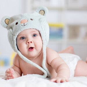 תינוק שוכב על ביטנו עם כובע