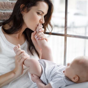 אם מנשקת את כפות רגליו של תינוקה