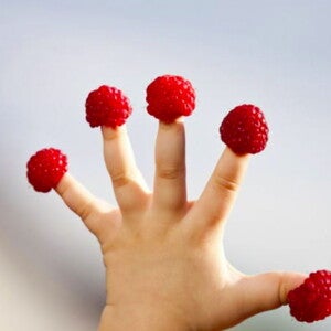 תותי עץ על אצבעותיו של פעוט