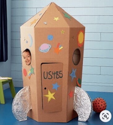 תינוק משחק בתוך קרטון צעצוע